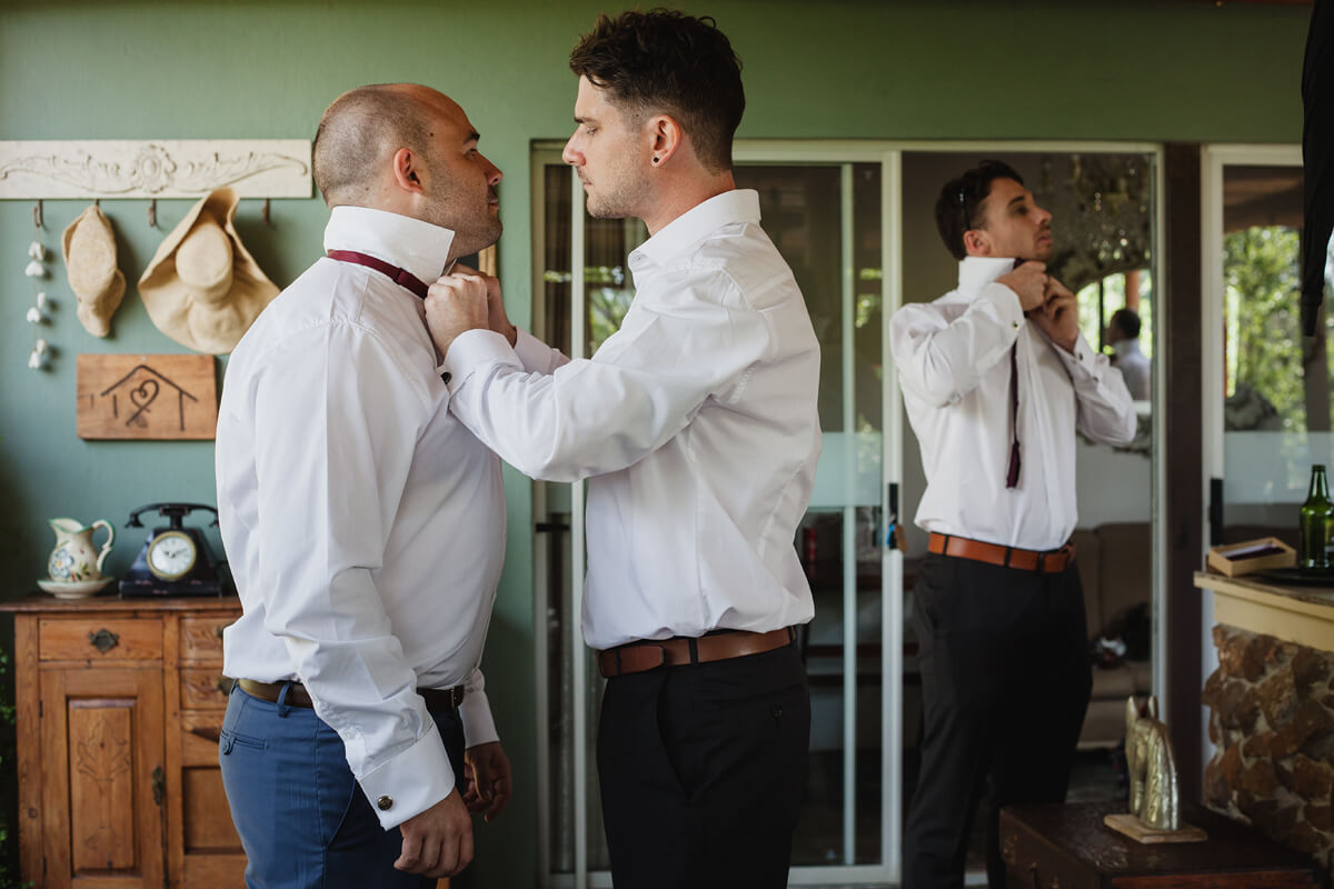 Groom and groomsmen fixing their bowties for the wedding at Cradle Valley Guest house in Gauteng