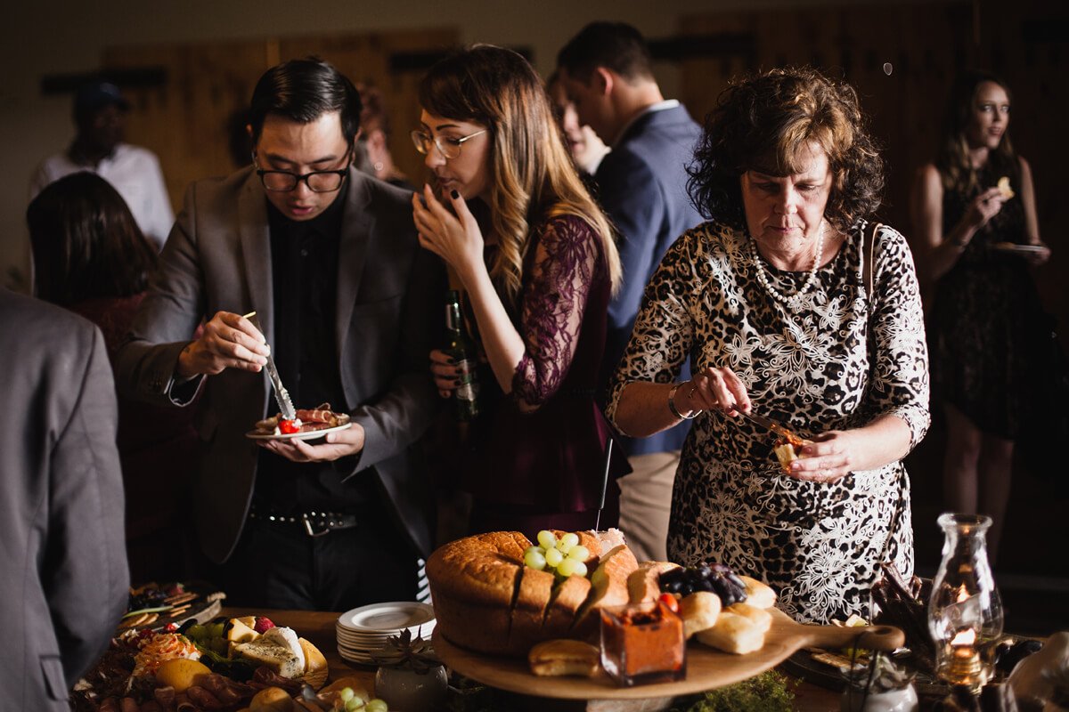 Guests dishing up canapes from charcuterie boards and bread tables at Cradle Valley wedding outside Johannesburg in Gauteng